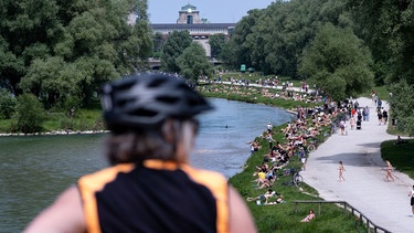 Zahlreiche Menschen genießen sommerliches Wetter am Ufer der Isar in der Münchner Innenstadt. | Bild: picture alliance/dpa | Sven Hoppe